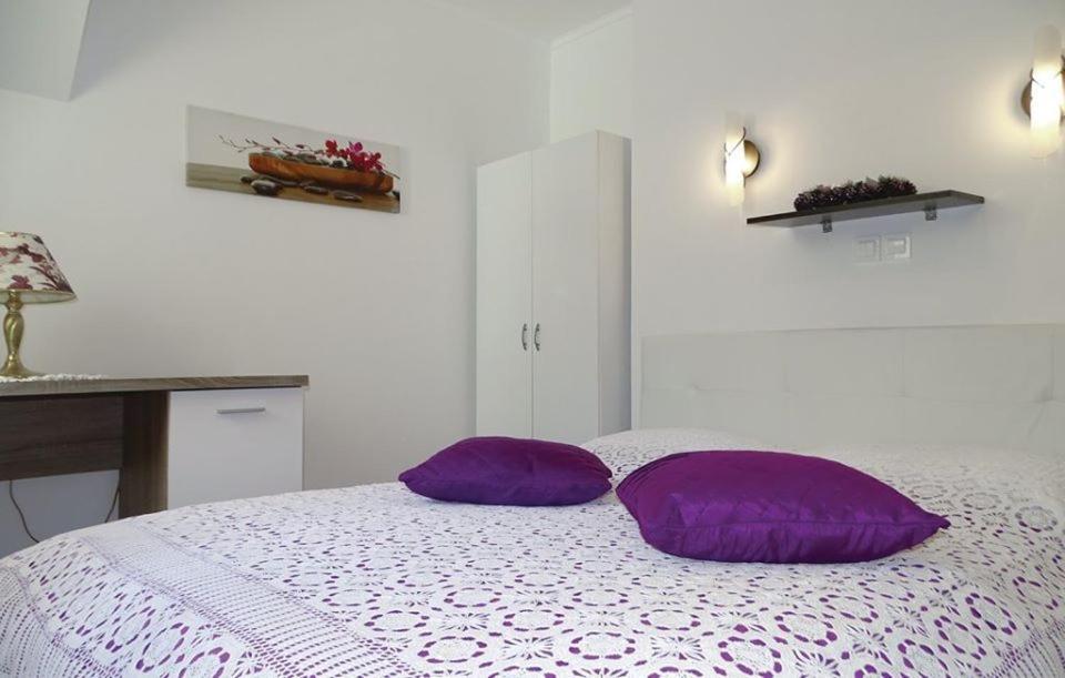 dos almohadas moradas sentadas en una cama en una habitación en Apartmaji Čujež, en Rečica ob Savinji