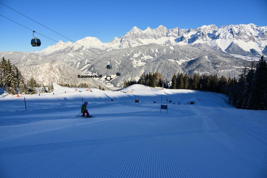 a person is skiing down a snow covered mountain at Saumerhof in Schladming