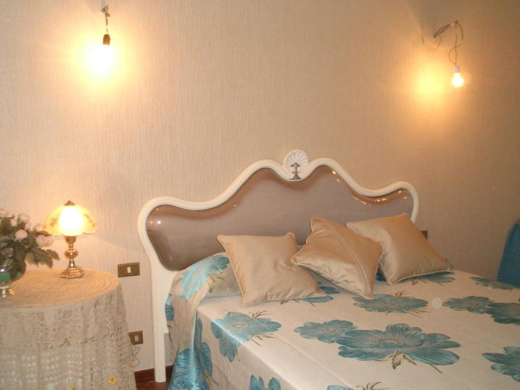 a bedroom with a bed with pillows and a table at Il Glicine di Carmen in Fondi