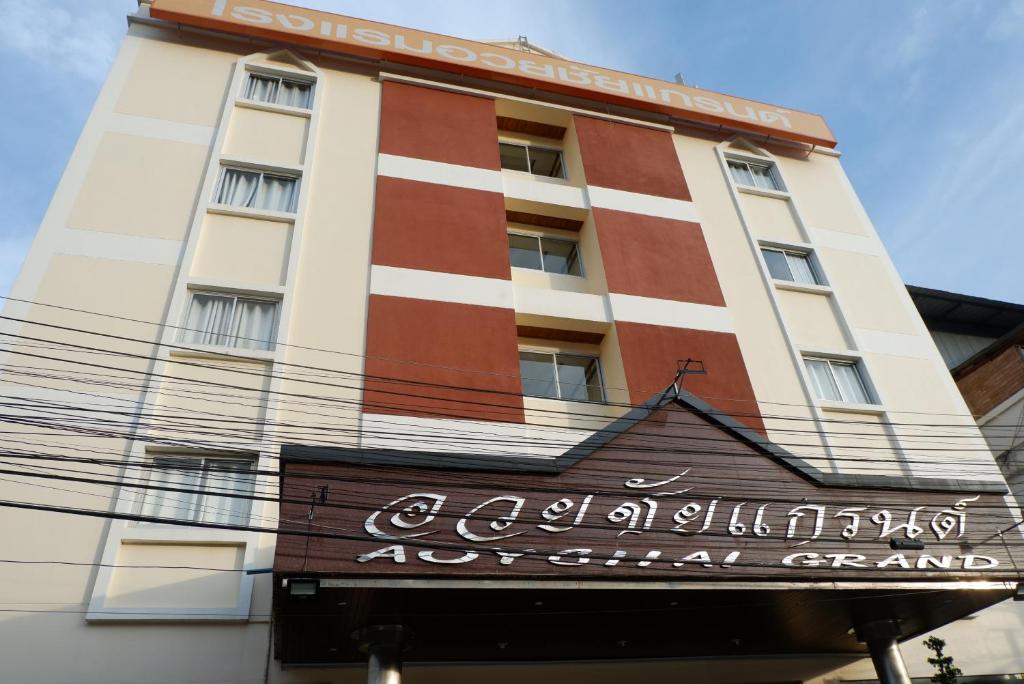un edificio con una señal delante de él en Auychai Grand Hotel en Lang Suan