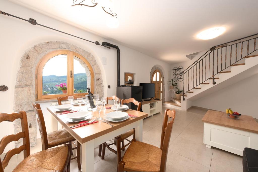 jadalnia ze stołem, krzesłami i schodami w obiekcie 2 Apartments in Old Stone House near Opatija w mieście Ičići