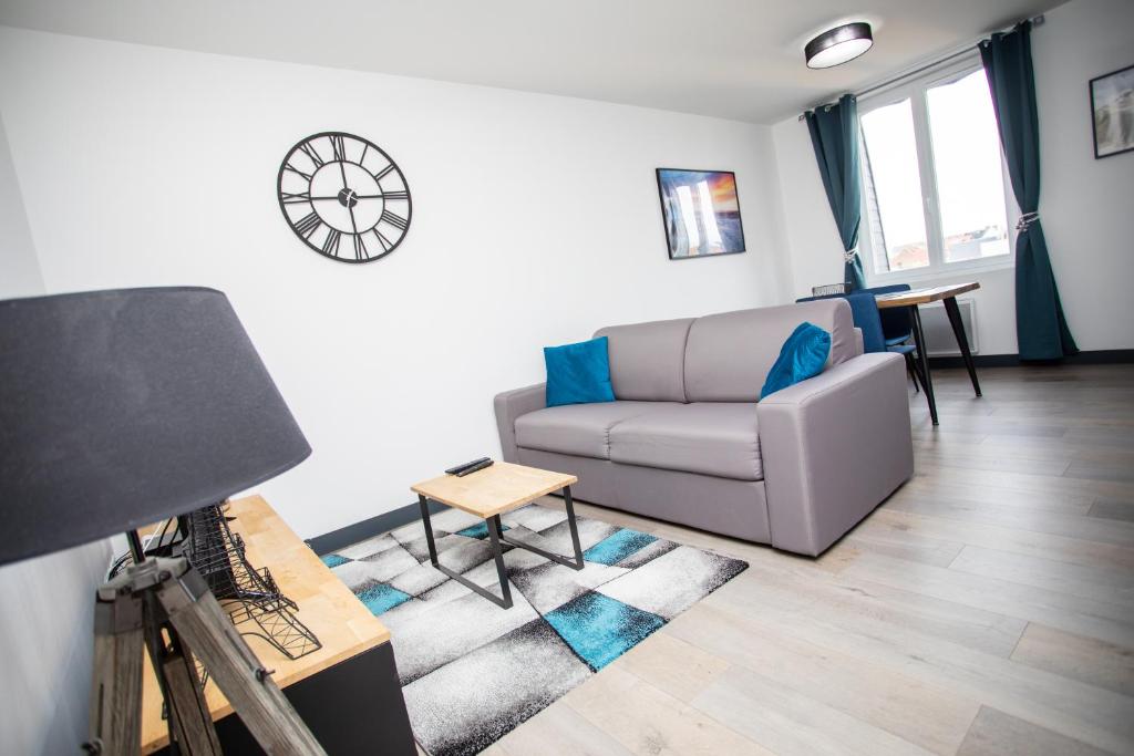 a living room with a couch and a table at Le ptit coin de la Baie in Fort-Mahon-Plage