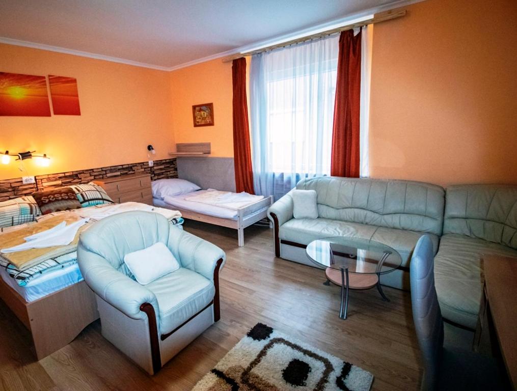 a living room with a couch and a bed at Krisztina Apartman in Nagykanizsa