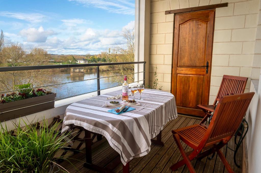 - une table sur un balcon avec vue sur la rivière dans l'établissement Côté Loire, à Amboise