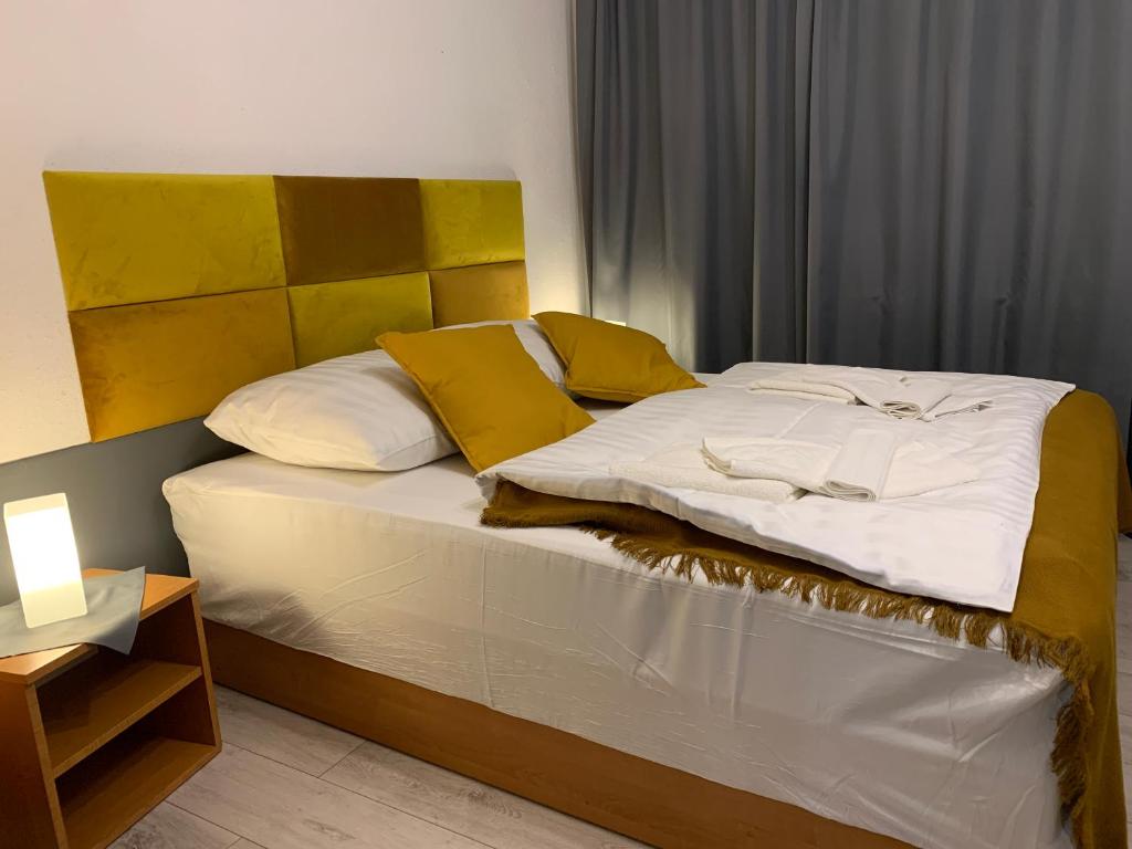 a bed with yellow and white pillows on it at 3 Kroki Do Lasu in Polanica-Zdrój