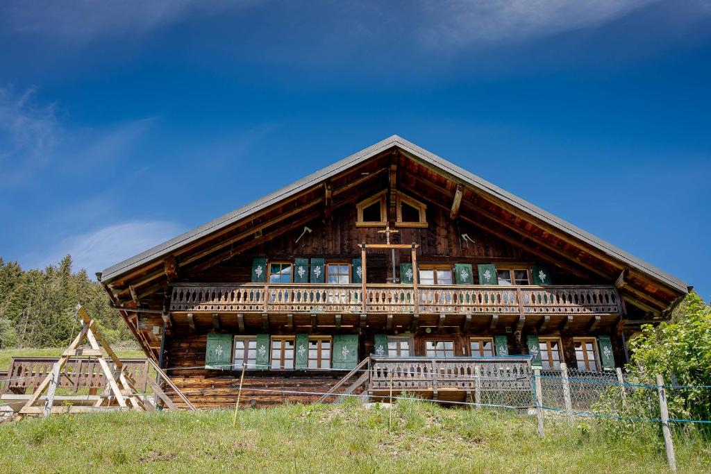 ein großes Holzhaus mit Balkon auf einem Hügel in der Unterkunft Chalet Les Planches in Val dʼIlliez