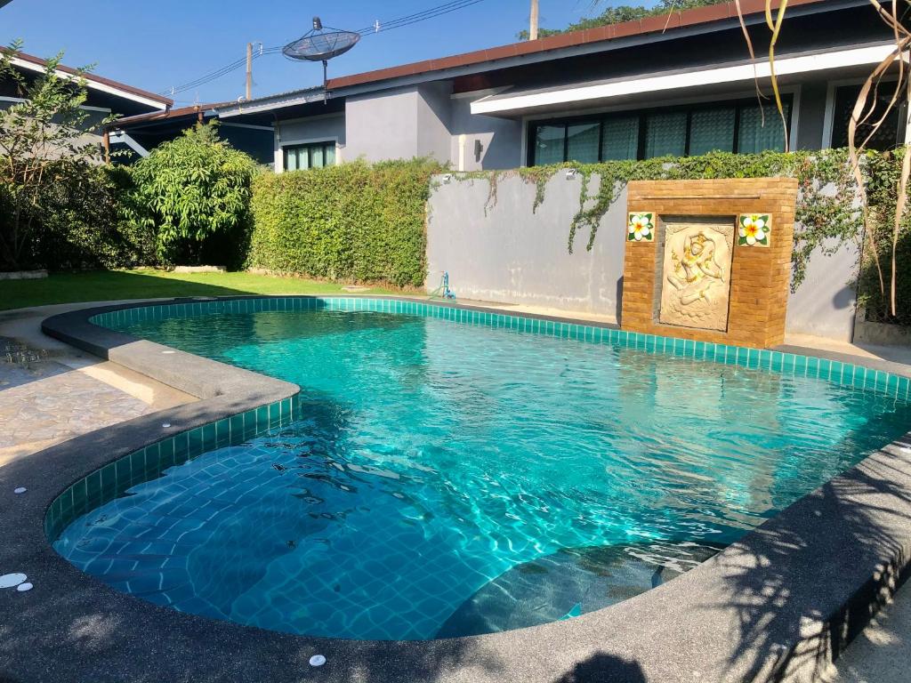 a swimming pool with blue water in a yard at My PoolVilla Cha am in Cha Am
