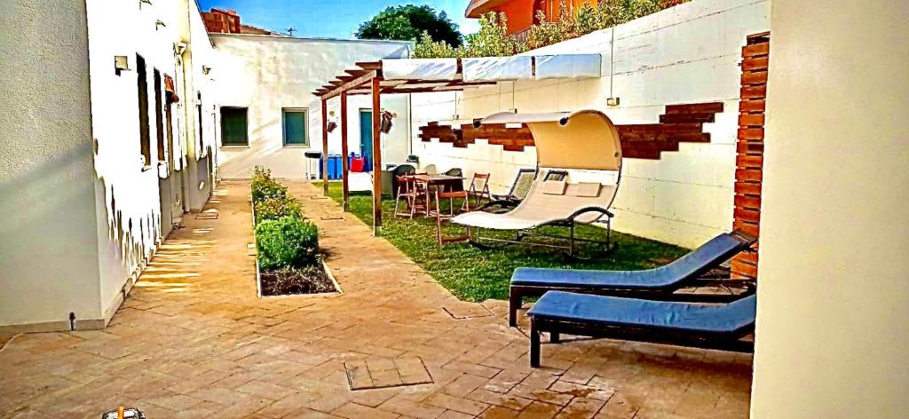 a patio with chairs and an umbrella and a table at Borghetto Mediterraneo in Santa Maria del Focallo
