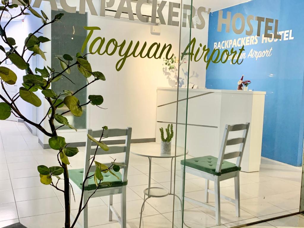 Backpackers' Hostel Taoyuan Airport في دايوان: غرفة بها كرسيين وطاولة