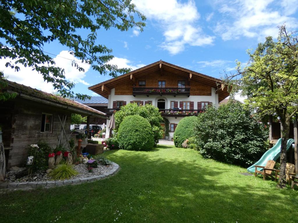 ein Haus mit einem grünen Garten davor in der Unterkunft Apartments Donebauer in Übersee