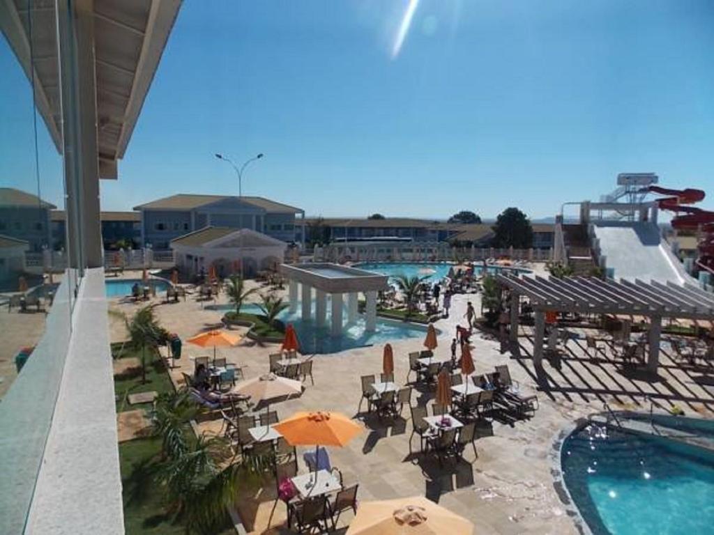 a pool with tables and umbrellas in a resort at Lacqua Di Roma - SUPER OFERTA in Caldas Novas