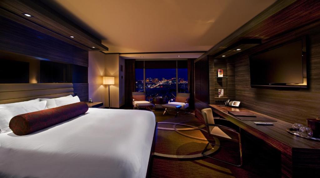 ein Hotelzimmer mit einem Bett und einem Schreibtisch mit Fernseher in der Unterkunft M Resort Spa &amp; Casino in Las Vegas