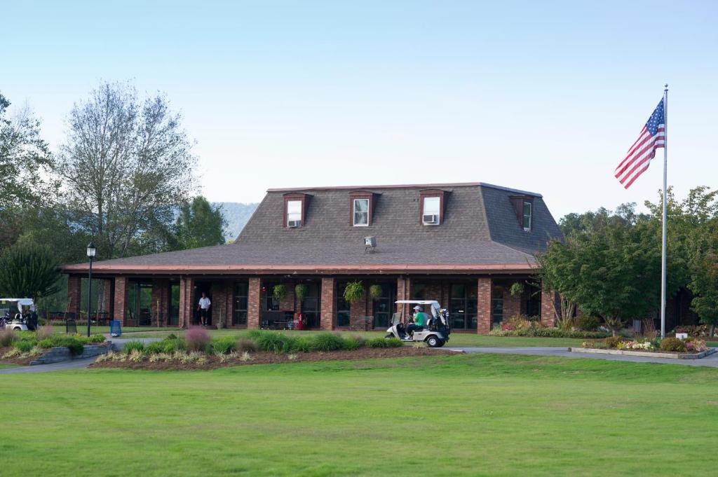 una casa con un carro de golf estacionado frente a ella en Etowah Valley Golf & Resort, en Etowah