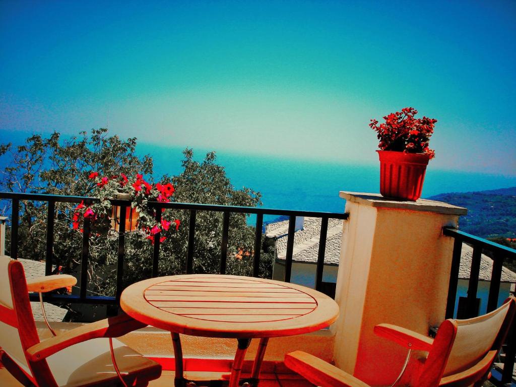 a table and chairs on a balcony with a pot of flowers at Muses Country House in Zagora