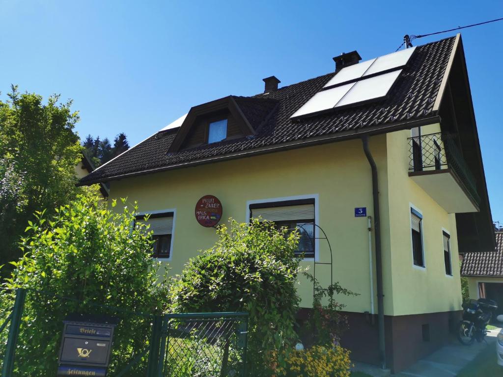 une maison jaune avec des panneaux solaires sur le toit dans l'établissement Haus Erika, à Völkermarkt