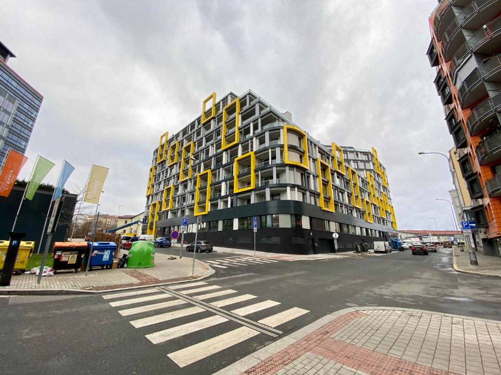 a building with yellow windows on a city street at Apartment David O2 Arena Prague in Prague