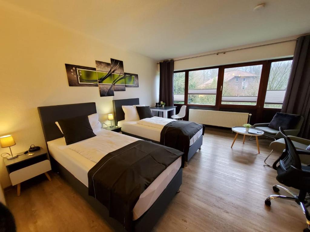 Cette chambre comprend deux lits et un bureau. dans l'établissement Hotel Seeblick am Sankelmarker See - Natur und Erholung, à Oeversee