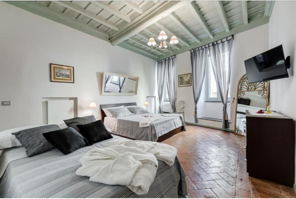 um quarto com 2 camas e uma televisão de ecrã plano em LauraLuxuryHome vista Fori Imperiali em Roma