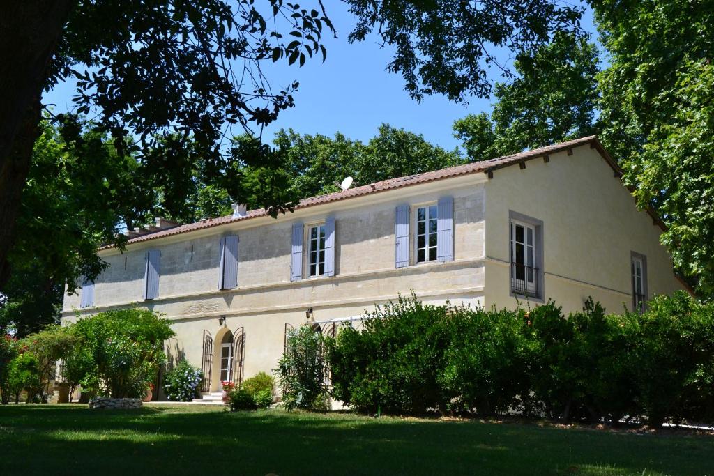 een groot wit huis met bomen ervoor bij Mas de Capelou in Avignon