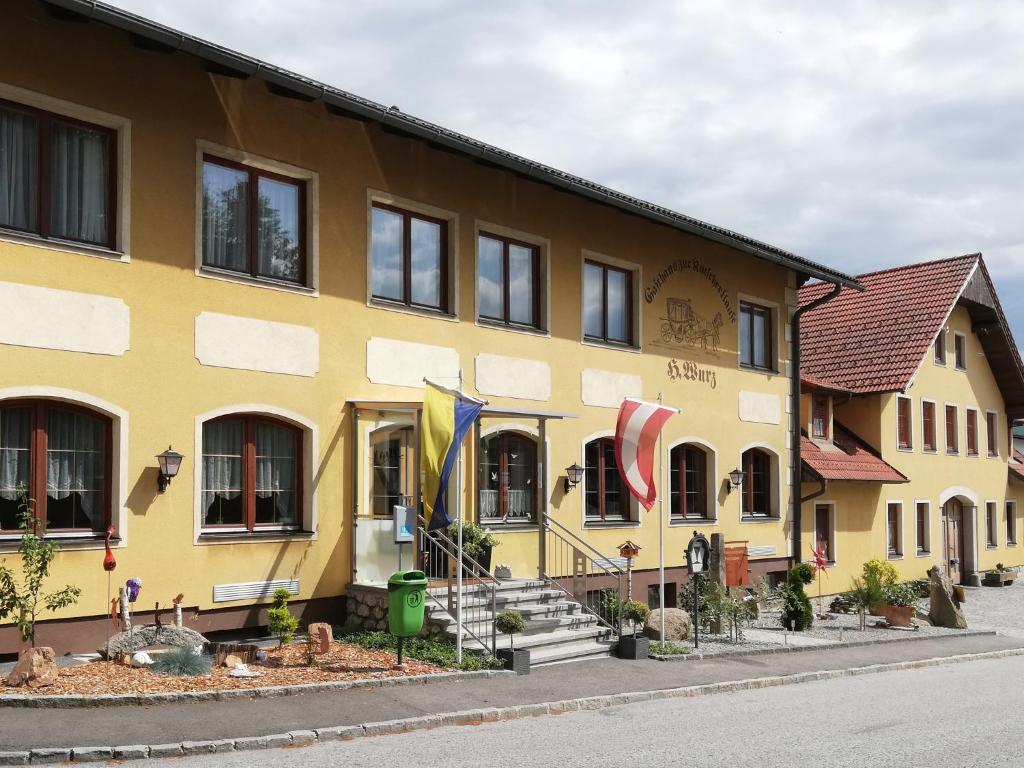 un edificio amarillo con banderas delante en Kutscherklause, en Eggern