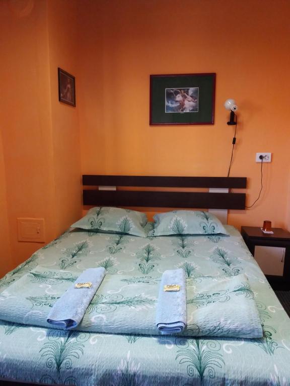 Una cama con dos toallas encima. en Стаи за гости ОРЕХА Троян Private rooms Oreha en Troyan