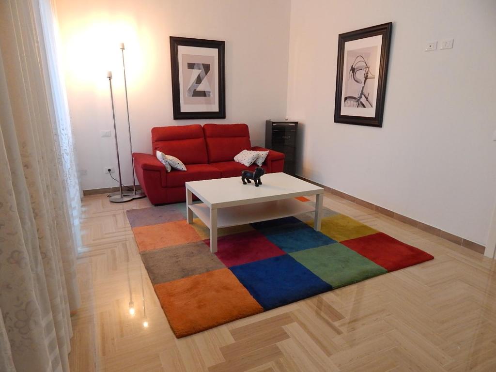 uma sala de estar com um sofá vermelho e um tapete colorido em la casa del parco Ferrari em Módena
