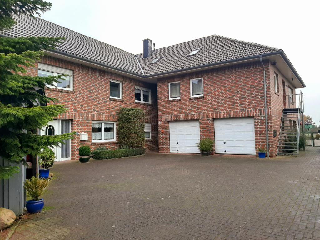 a brick house with two white garage doors at Kastner Monteurwohnung in Neubörger