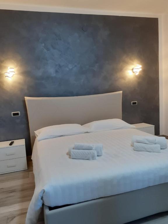 um quarto com uma grande cama branca com toalhas em Giosam bed & breakfast em Pozzilli