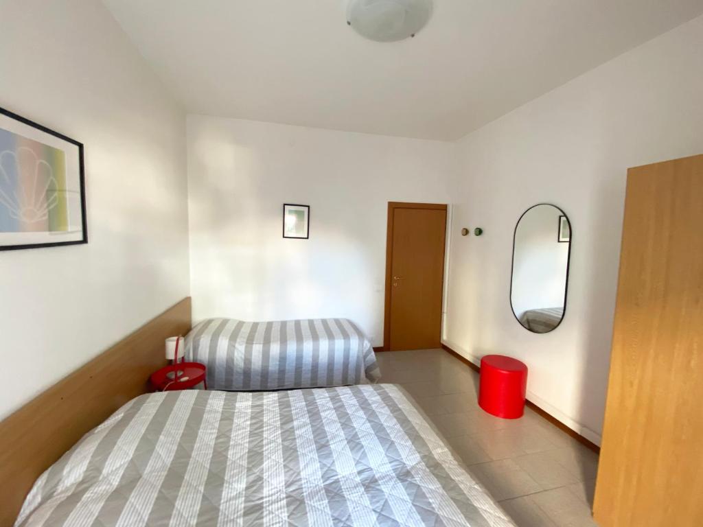 Dormitorio pequeño con cama y espejo en Dainese Apartments, Casa Ester, en Lido di Jesolo