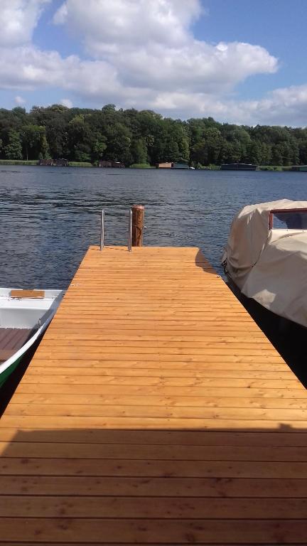 un muelle de madera en un barco en el agua en Ferienwohnung am See en Malchow