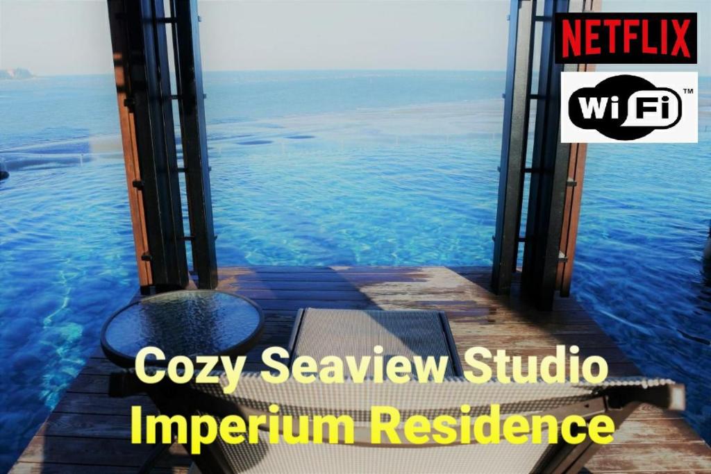 a view of the ocean with a bench on a dock at Cozy Seaview Studio at Imperium residence Tanjung Lumpur Kuantan in Kuantan