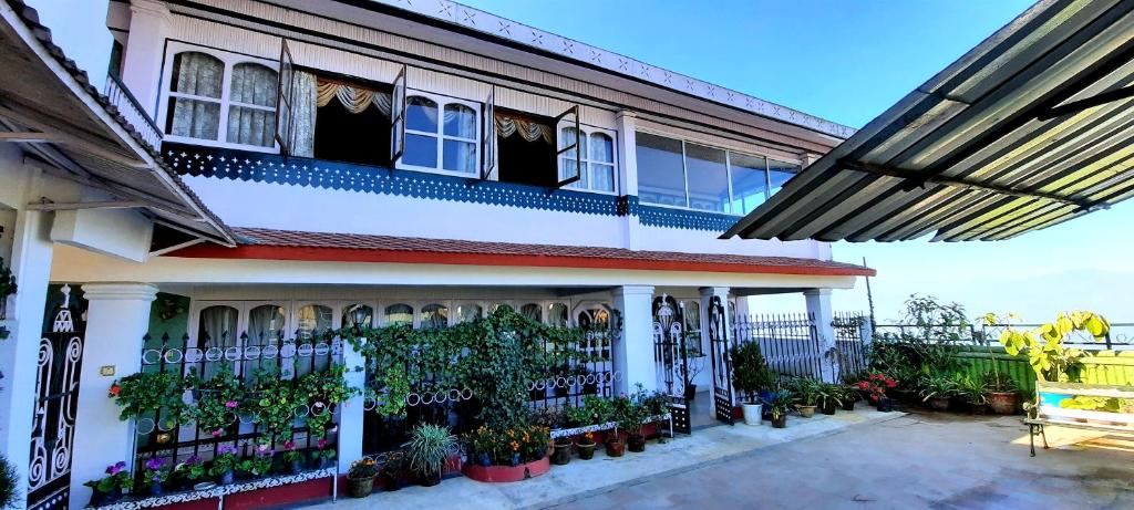 a building with potted plants in front of it at Yuma D Homestay in Darjeeling