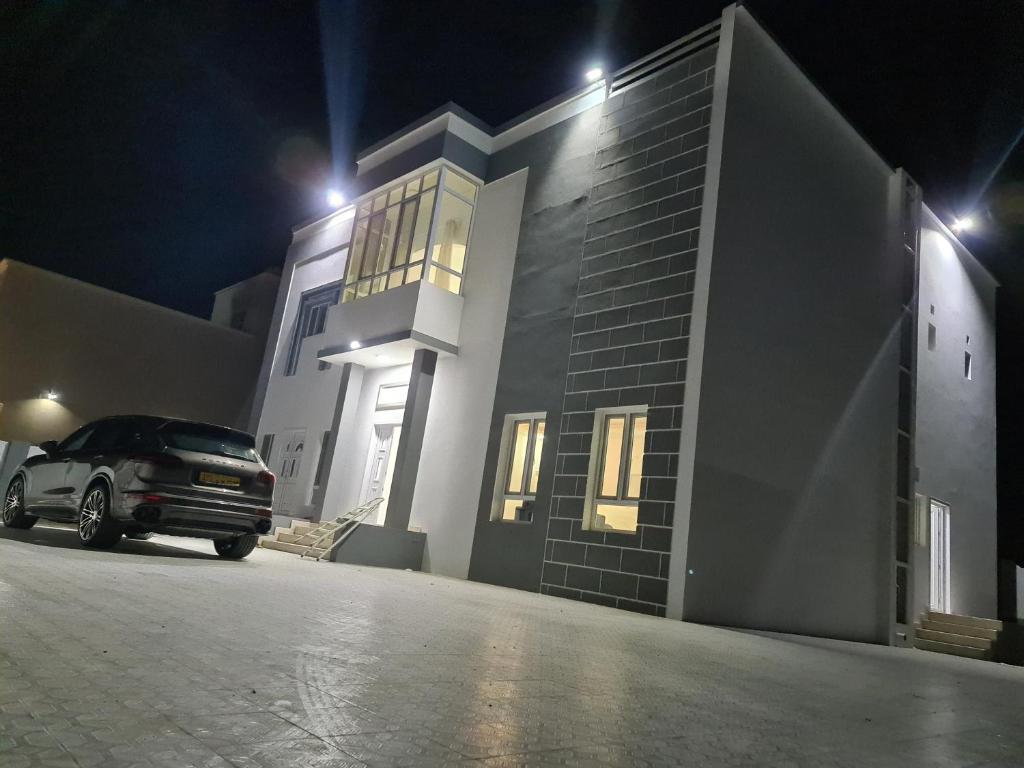 a car parked in front of a building at night at فلة ايكيا in Sohar