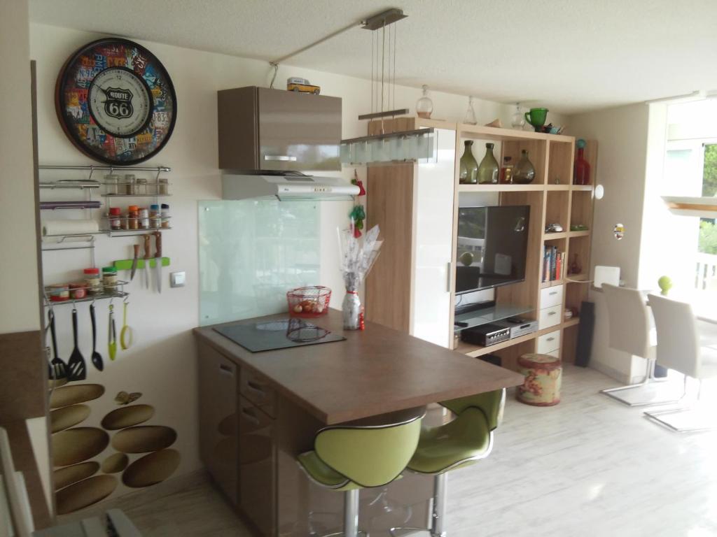 a kitchen with a table and some green bar stools at APPART MER CALME ET ENSOLEILLEE in Le Grau-du-Roi