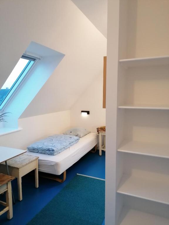 a small room with a bed and a book shelf at Femmasteren Hotel & Hostel in Marstal