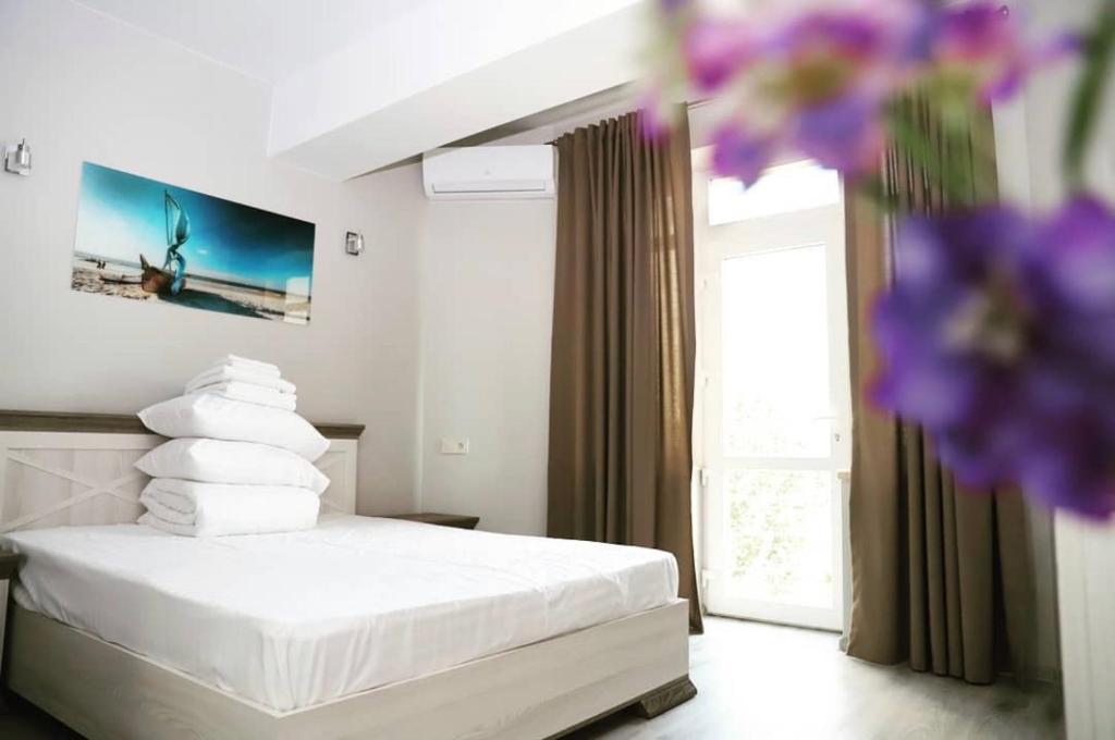 a bedroom with a bed with white sheets and a window at Foton Hotel & Restaurant in Ochakiv