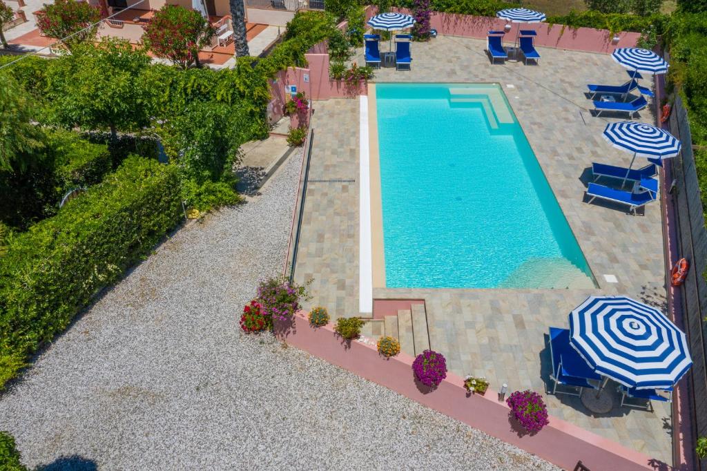 een uitzicht over een zwembad met stoelen en parasols bij Elbaloves Appartaments Villa in Capoliveri