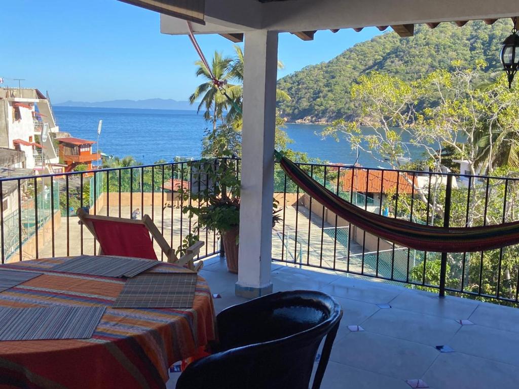 a balcony with a hammock and a view of the ocean at Casa Choco in Yelapa