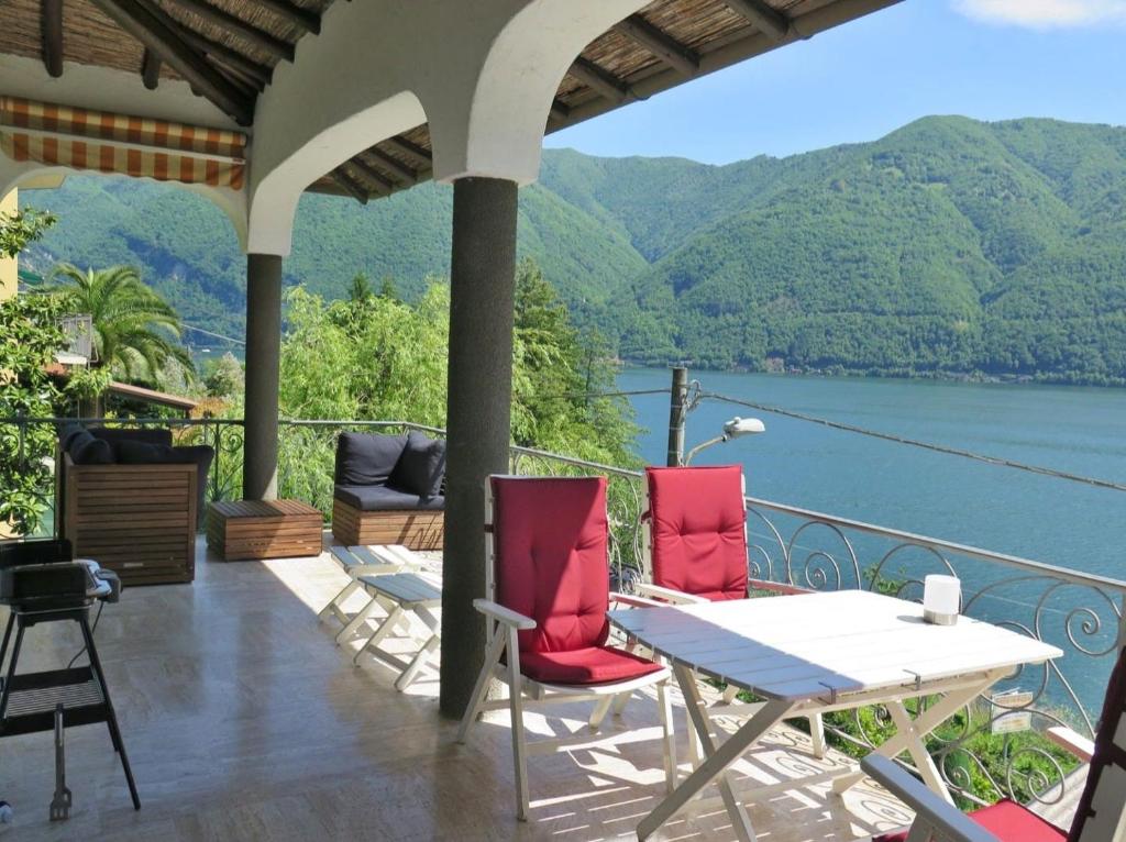 a porch with a table and chairs and a view of the water at Cima Caravina in Cima