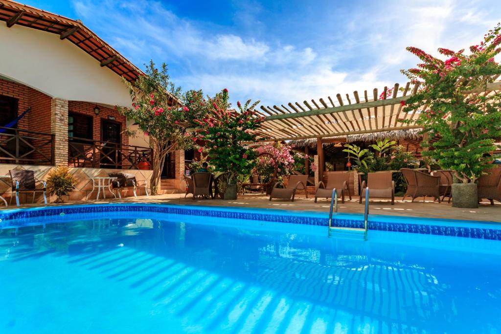 una piscina de agua azul en un complejo en Jardim dos Orixás en Canoa Quebrada