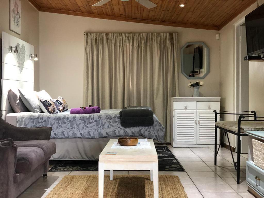 Sala de estar con cama y mesa en Rest and Rise, en Pietermaritzburg