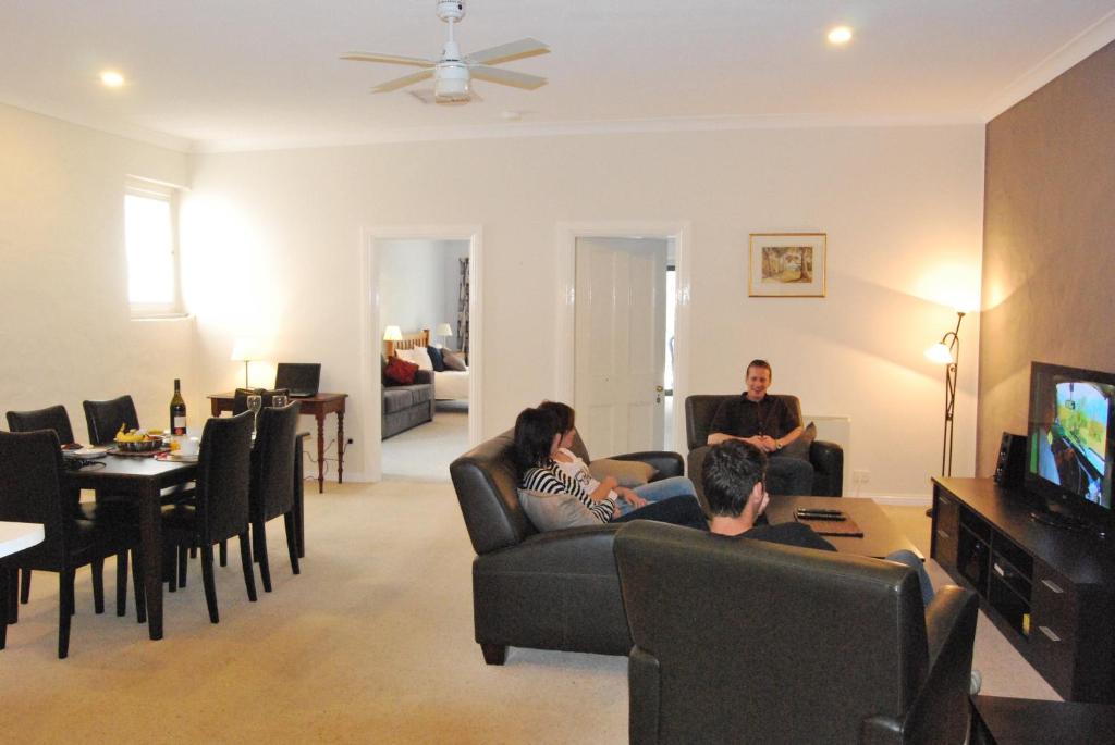 a group of people sitting in a living room watching tv at Brayfield Cottage in Murray Bridge