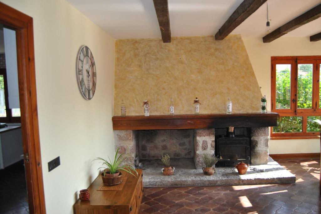 - un salon avec une cheminée en pierre dans une maison dans l'établissement Finca Arroyo del Valle, à San Andrés del Rabanedo