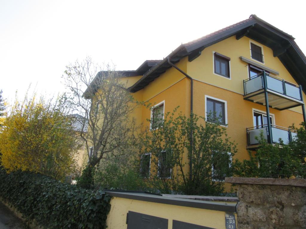 een geel huis met een hek ervoor bij Appartement-Heuberg in Salzburg