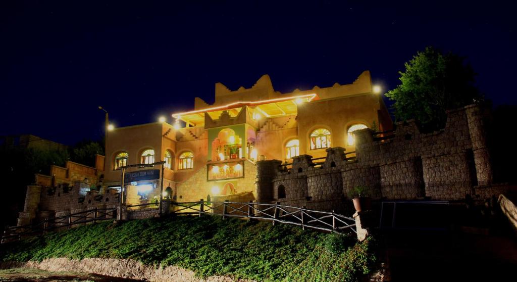 duży zamek w nocy z oświetleniem w obiekcie Kasba Oum Hani d'Ouzoud w mieście Ouzoud