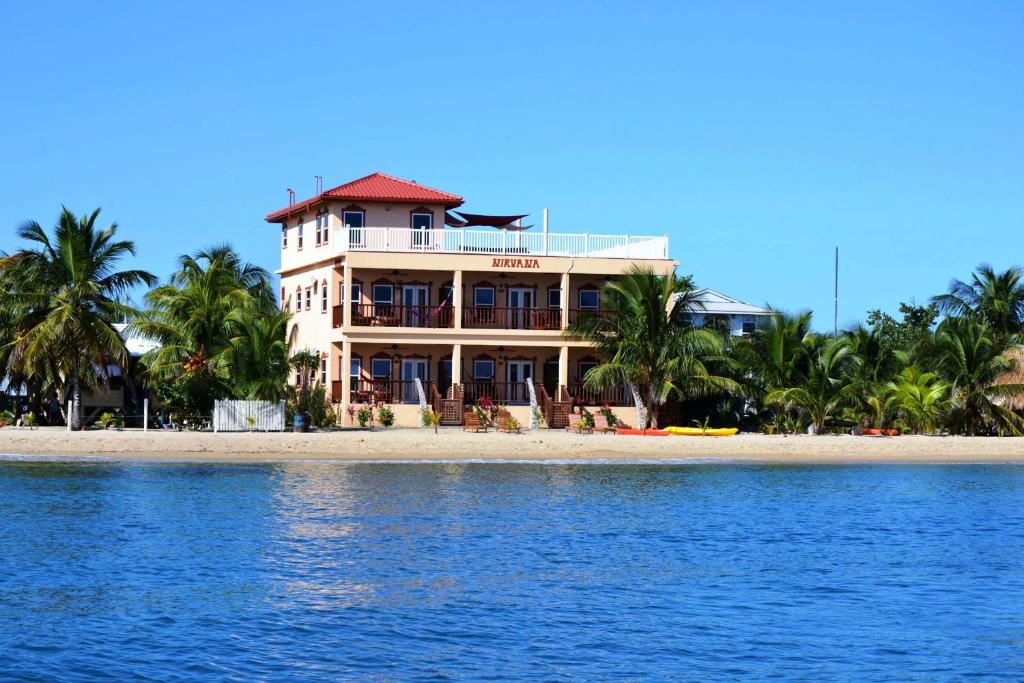 ein großes Haus am Strand mit dem Wasser in der Unterkunft Belizean Nirvana in Placencia Village