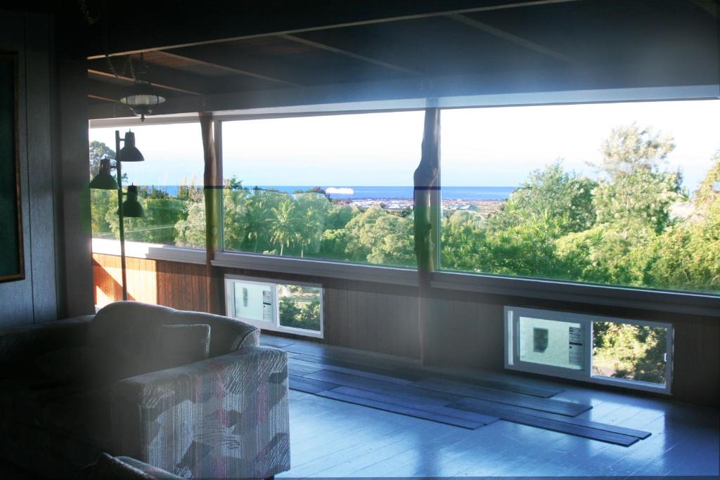 a living room with a couch and a large window at Aeolian Ranch Guest house in Kailua-Kona