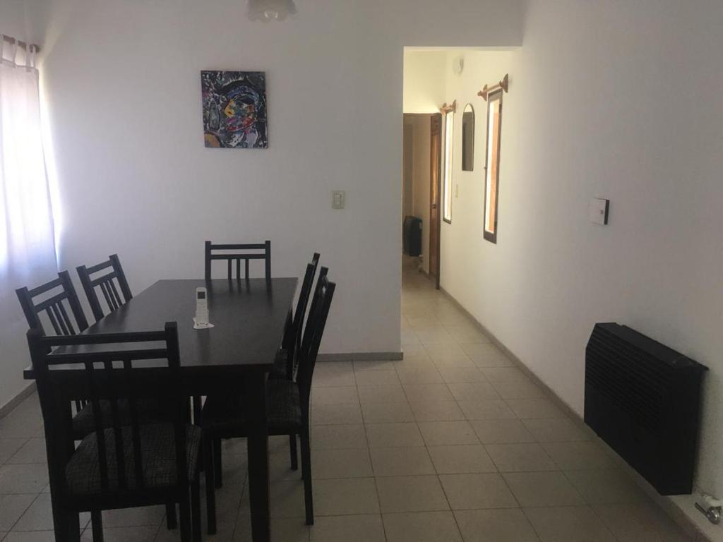 Departamento Serpa في سيوداد لوجان دي كويو: غرفة طعام مع طاولة وكراسي وممر