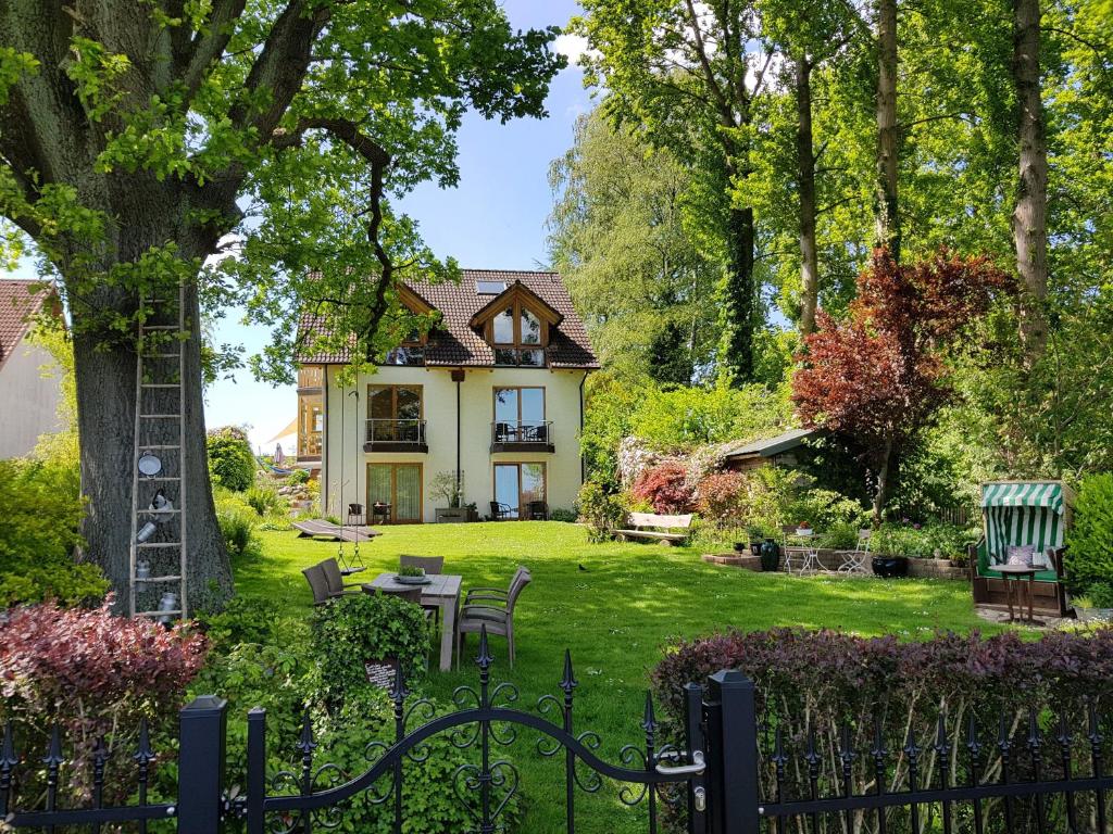 ein Haus mit einem Hof mit einem Zaun in der Unterkunft Bellevue in Malente