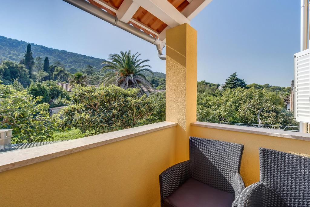 a balcony with two chairs and a view of the mountains at Apartment Karin in Veli Lošinj